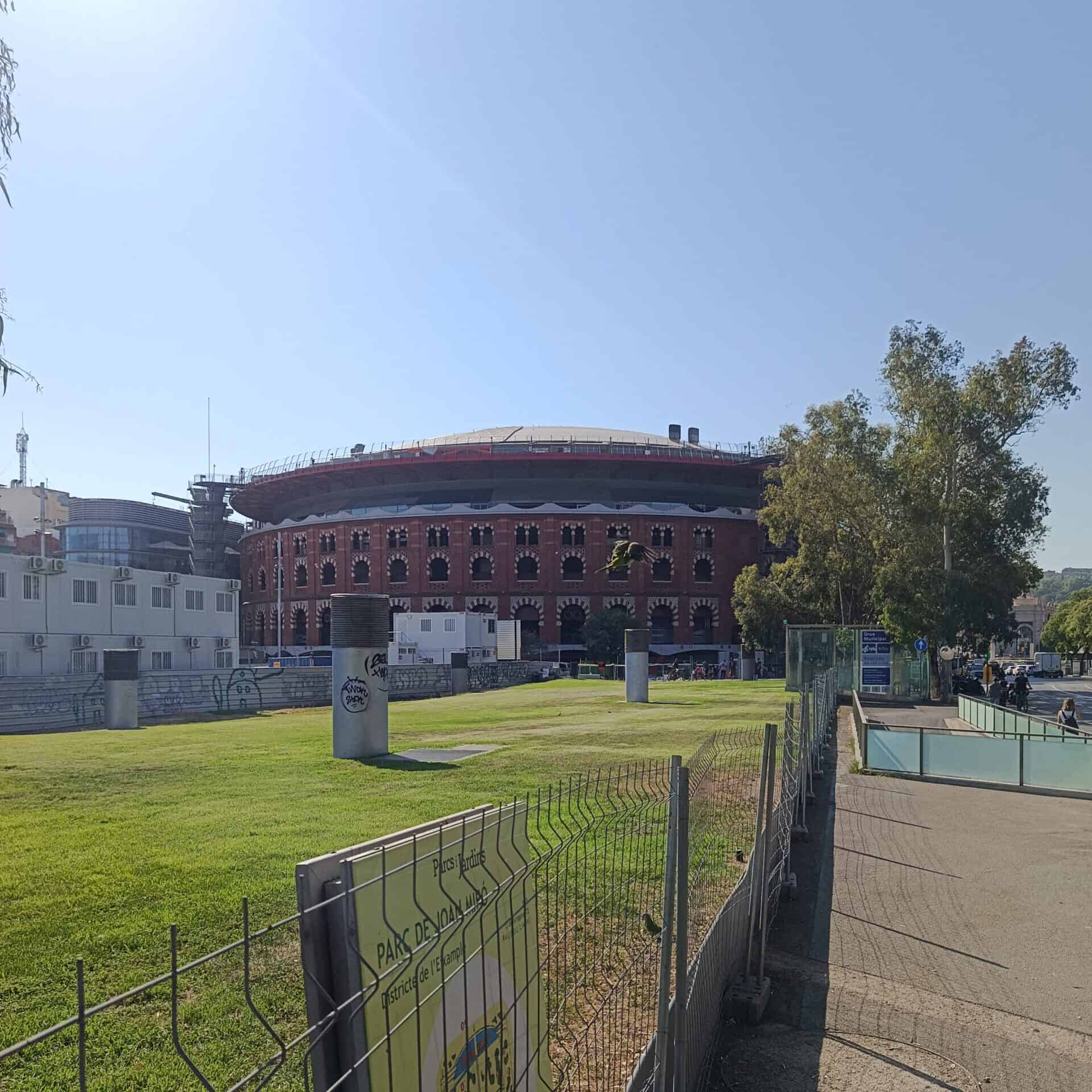 Historic baseball stadium with brick facade and green field under clear sky.