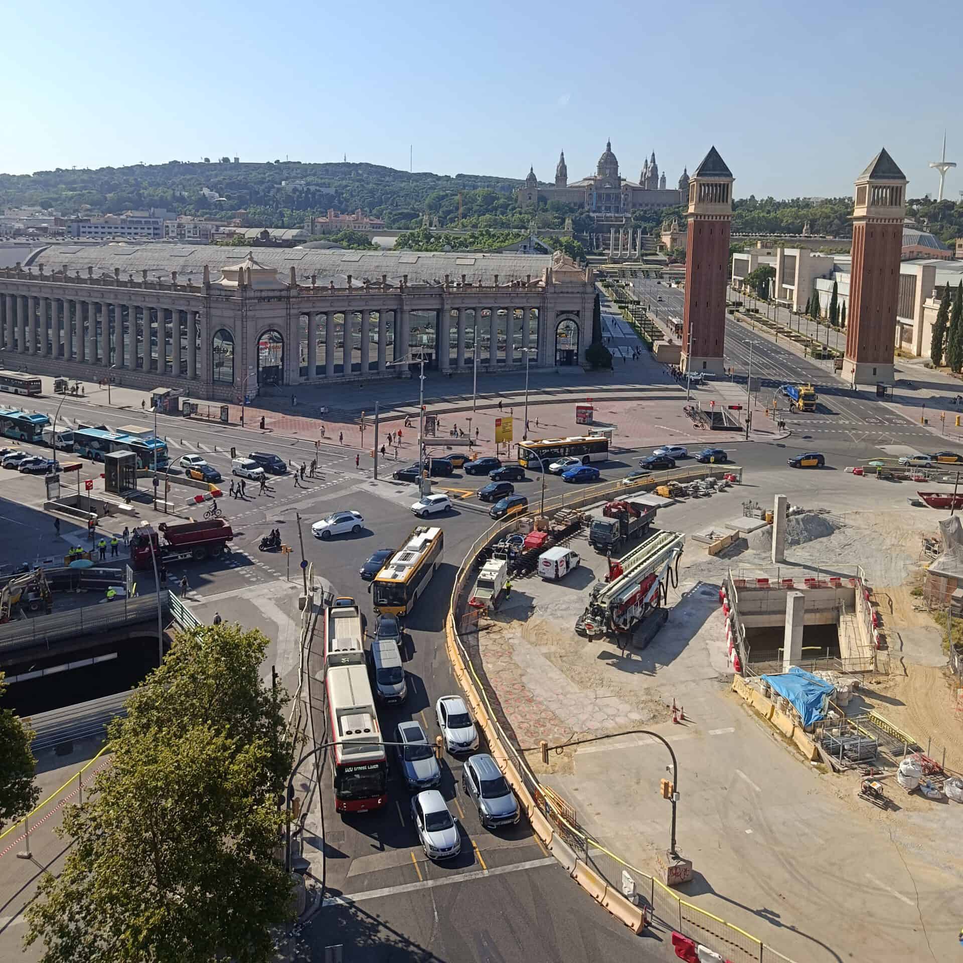 Construction site at Barcelona Sants station with buses and vehicles.
